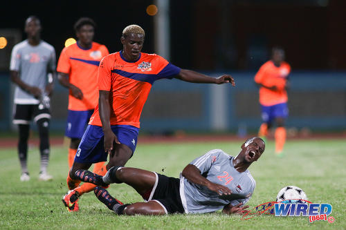 Photo: Club Sando attacker Akee Roach (left) looks to glide past fallen Central FC defender Kevon Villaroel during Pro League action at the Ato Boldon Stadium on 16 December 2016. (Courtesy Chevaughn Christopher/Wired868)