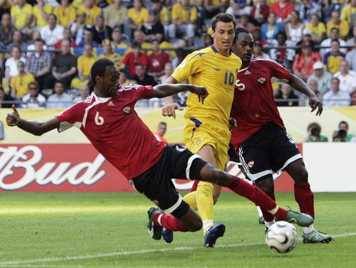 Photo: Trinidad and Tobago defender Dennis Lawrence (left) tackles Sweden forward Zlatan Ibrahimovic (centre) during the 2006 World Cup at the Dortmund stadium on 10 June 2016. Looking on is Brent Sancho. (Copyright AFP 2016/Sven Nackstrand)