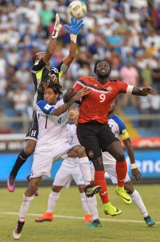 Photo: Trinidad and Tobago forward Kenwyne Jones (right) jumps with Honduras goalkeeper Donis Escober (left) and defender Henry Figueroa during their 2018 World Cup qualifier in San Pedro Sula, Honduras, on 15 November 2016. (Copyright AFP 2017/Gerardo Mazariegos)