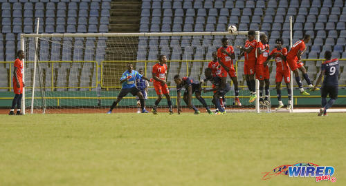 Photo: Morvant Caledonia United goalkeeper Marvin Phillip (second from left) senses danger as Defence Force striker Devorn Jorsling (far right) lofts his free kick over the defensive wall during Pro League action at the Hasely Crawford Stadium on 17 January 2017. (Courtesy Sean Morrison/Wired868)