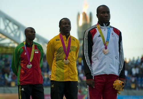 Photo: Trinidad and Tobago’s bronze medallist Emmanuel Callender (right), Jamaica’s gold medallist Lerone Clarke (centre) and Saints Kitts and Nevis’ Silver medallist Kim Collins take to the podium after the 100m final of the Guadalajara 2011 XVI Pan American Games in Guadalajara, Mexico on 25 October 2011. (Copyright AFP 2017/Luis Acosta)