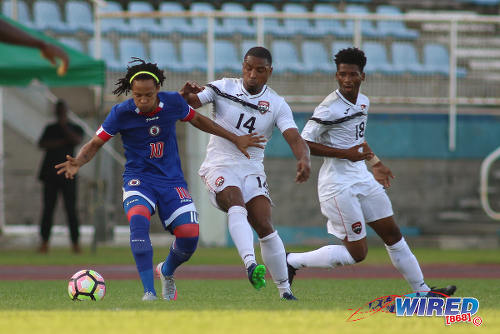 Photo: Haiti playmaker Hérold Charles (left) tries to keep the ball from Trinidad and Tobago midfielder Andre Boucaud (centre) while Aikim Andrews looks on during 2017 Gold Cup playoff action at the Ato Boldon Stadium in Couva. (Courtesy Chevaughn Christopher/Wired868)