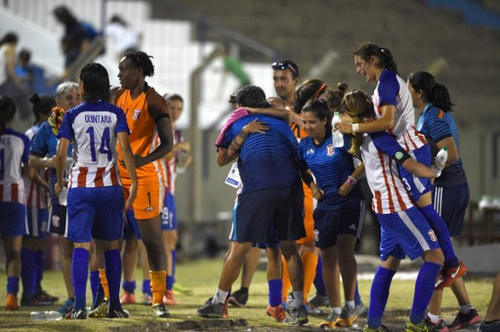 Photo: Trinidad and Tobago goalkeeper Kimika Forbes (third from left) celebrates with teammates of Paraguayan club, Sportivo Limpeño, after their triumph over Brazil’s Adi Foz Catarata in the Copa Libertadores women’s semifinal at the Suppici stadium in Colonia, Uruguay on 17 December 2016. (Copyright AFP 2017/Pablo Porciuncula)