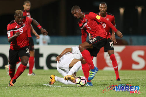 Photo: Trinidad and Tobago midfielder Hashim Arcia (right) tries to sidestep a Surinamese tackle while teammate Akeem Roach (left) tries to make a run during 2017 Gold Cup playoff action at the Ato Boldon Stadium, Couva on 4 January 2017. (Courtesy Chevaughn Christopher/Wired868)