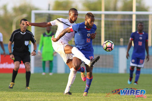 Photo: Trinidad and Tobago midfielder Kevan George (left) tackles Haiti substitute Listner Pierre-Louis during 2017 Gold Cup playoff action at the Ato Boldon Stadium in Couva. (Courtesy Chevaughn Christopher/Wired868)