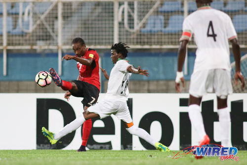 Photo: Trinidad and Tobago winger Tyrone Charles (left) whips a cross past Suriname right back Miquel Darson during 2017 Gold Cup playoff action at the Ato Boldon Stadium, Couva on 4 January 2017. (Courtesy Chevaughn Christopher/Wired868)