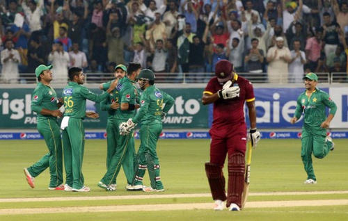 Photo: West Indies batsman Andre Fletcher (centre) heads back to the pavilion after falling victim to Pakistan bowler Imad Wasim (third from left) during the first T20I match at the Dubai International Cricket Stadium on 23 September 2016.  (Copyright AFP 2017/Karim Sahib)