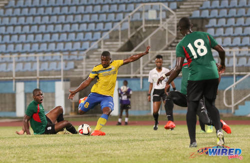 Photo: Defence Force midfielder Chris Durity (centre) goes for goal while Club Sando midfielder Keithy Simpson (far left) and referee Crystal Sobers (centre) look on during Digicel Pro Bowl quarterfinal action at the Ato Boldon Stadium in Couva on 9 February 2017. (Courtesy Sean Morrison/Wired868)