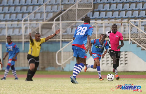 Photo: Referee Rashby McFee (second from left) motions to play on as Central FC attacker Rundell Winchester (far right) runs at the St Ann's Rangers defence during Digicel Pro Bowl quarterfinal action at the Ato Boldon Stadium in Couva on 9 February 2017. (Courtesy Sean Morrison/Wired868)