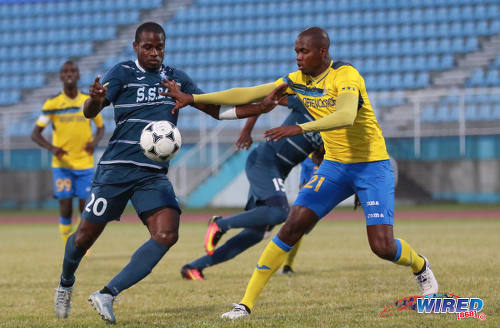 Photo: Police FC attacker Elijah Belgrave (left) tries to create room against Defence Force left back Akile Edwards during the Pro Bowl semifinals at the Ato Boldon Stadium on 12 February 2017. Defence Force won 4-0. (Courtesy Sean Morrison/Wired868)