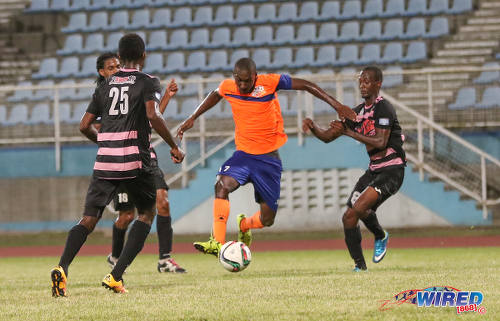 Photo: Club Sando midfielder Jared London (centre) tries to force his way past Ma Pau Stars players (from left) Keryn Navarro, Jordan Devonish and Adrian Noel during Digicel Pro Bowl quarterfinal action at the Ato Boldon Stadium in Couva on 9 February 2017. (Courtesy Sean Morrison/Wired868)