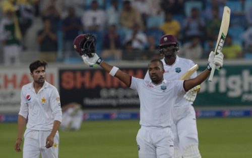 Photo: West Indies batsman Darren Bravo (right) raises his bat and helmet to celebrate a century against Pakistan as team captain Jason Holder (back) and Pakistani bowler Mohammad Amir look on during the final day of the first day-night Test between Pakistan and the West Indies at the Dubai International Cricket Stadium in the Gulf Emirate on 17 October 2016. (Copyright AFP 2017/Aamir Qureshi)