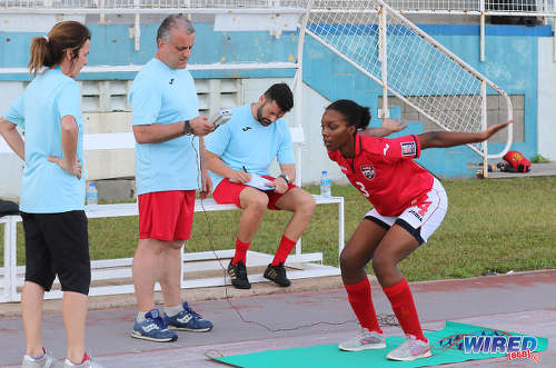 Photo: Trinidad and Tobago Women's National Senior Team assistant coach Elisabetta Bavagnoli (far left) and an unnamed fitness trainer (centre) and goalkeeping coach help a national player through her routine during practice at the Ato Boldon Stadium, Couva on 1 February 2017. (Courtesy Sean Morrison/Wired868)