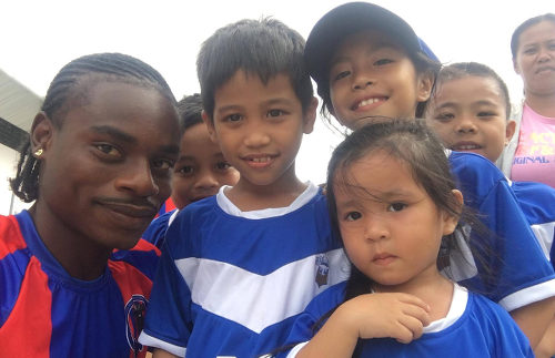 Photo: Trinidad and Tobago midfielder Darren Mitchell (left) meets young football fans of Davao Aguilas FC in the Philippines.