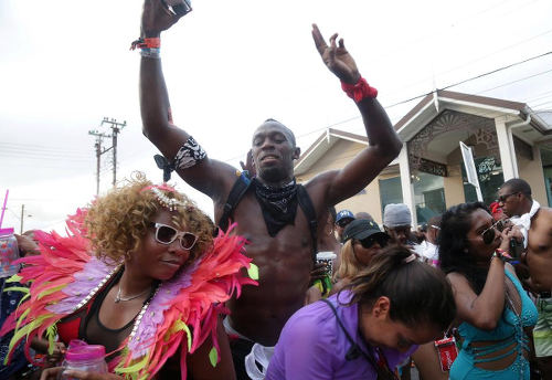 Photo: Jamaica sprint star and global sport icon Usain Bolt (centre) enjoys himself during the 2017 Carnival celebrations. (Copyright UK Sun)