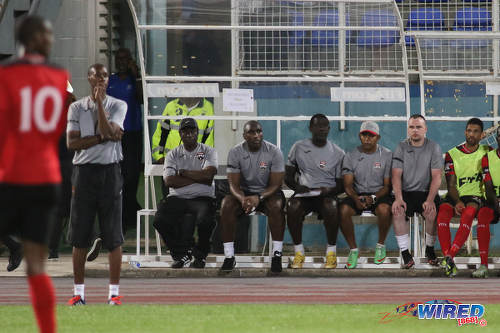 Photo: Trinidad and Tobago National Senior Team head coach Dennis Lawrence (second from left) and half of his technical staff who are (from right) Stephen Bradley, Riedoh Berdien, Ross Russell, Sol Campbell and Stuart Charles-Fevrier take in the action during their friendly international outing against Barbados on 10 March 2017. Lawrence was without assistant coach Stern John, who lost his daughter, Nikela, to a tragic mishap on the eve of the game. (Courtesy Chevaughn Christopher/Wired868)