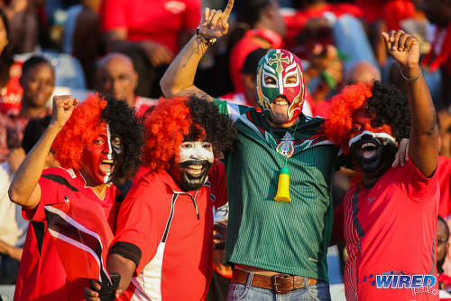 Photo: A Mexico football fan (centre) poses with Trinidad and Tobago football fans before kick off of the Russia 2018 World Cup qualifying meeting at the Hasely Crawford Stadium in Port of Spain on 28 March 2017. Mexico won 1-0. (Courtesy Chevaughn Christopher/Wired868)