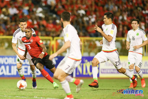 Photo: Trinidad and Tobago winger Joevin Jones (second from left) takes on the Mexico defence during 2018 FIFA World Cup qualifying action at the Hasely Crawford Stadium in Port of Spain on 28 March 2017. (Courtesy Chevaughn Christopher/Wired868)