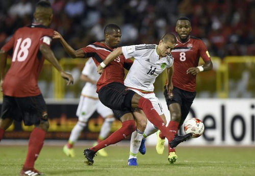 Photo: Mexico forward Javier Hernandez (right) tries unsuccessfully to evade a tackle from Trinidad and Tobago midfielder Kevan George during 2018 FIFA World Cup qualifying action at the Hasely Crawford Stadium in Port of Spain on 28 March 2017. (Copyright AFP 2017/Alfredo Estrella)