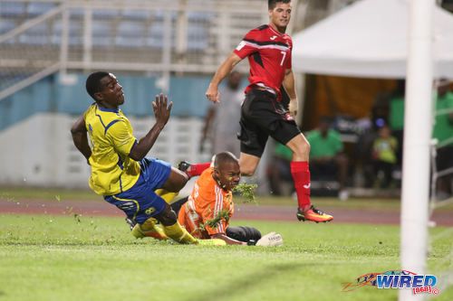 Photo: Trinidad and Tobago midfielder Sean De Silva (right) beats Barbados goalkeeper Dario Weir (centre) and a retreating defender but not the upright during international friendly action at the Ato Boldon Stadium in Couva on 10 March 2017.  Trinidad and Tobago won 2-0.  (Courtesy Chevaughn Christopher/Wired868)