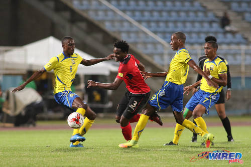 Photo: Trinidad and Tobago defender Triston Hodge (centre) tries to wriggle past some Barbados opponents during international friendly action at the Ato Boldon Stadium in Couva on 10 March 2017. (Courtesy Chevaughn Christopher/Wired868)