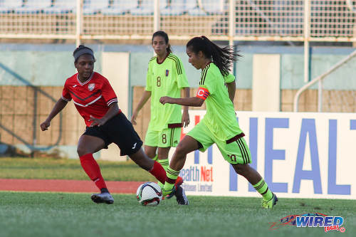 Photo: Trinidad and Tobago midfielder Mia Walcott (left) tries to keep an eye on Venezuela playmaker and captain Paola Villamizar during international friendly action at the Ato Boldon Stadium in Couva on 26 March 2017. (Courtesy Chevaughn Christopher/Wired868)