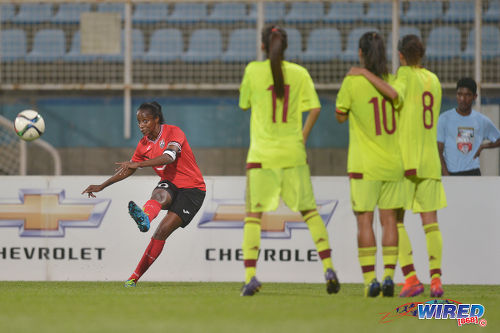 Photo: Trinidad and Tobago captain and attacker Tasha St Louis (left) curls a free kick towards goal during international friendly action against Venezuela at the Ato Boldon Stadium in Couva on 29 March 2017. Venezuela won 3-1. (Courtesy Chevaughn Christopher/Wired868)