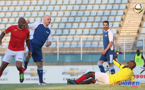 Photo: FIFA president Gianni Infantino (second from left) puts the FIFA/TTFA XI ahead with an effort that deflected off a defender and looped over the head of the Ministry of Sport/SPORTT XI goalkeeper during an exhibition match at the Ato Boldon Stadium in Couva on 10 April 2017. Looking on (right) is former Colombia international Juan Pablo Angel. (Courtesy Sean Morrison/Wired868)