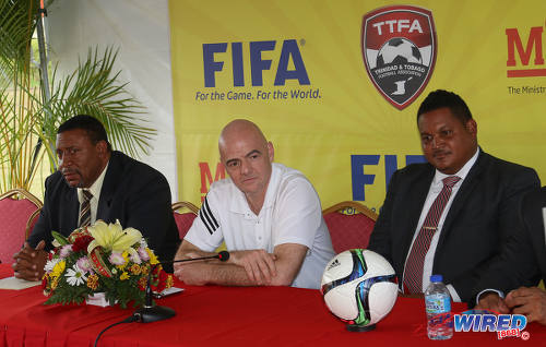 Photo: FIFA president Gianni Infantino (centre) momentarily loses his smile as he considers a Wired868 question on racism at a press conference at the Ato Boldon Stadium in Couva on 10 April 2017. Sitting on either side of Infantino are TTFA president David John-Williams (left) and Sport Minister Darryl Smith. (Courtesy Sean Morrison/Wired868)