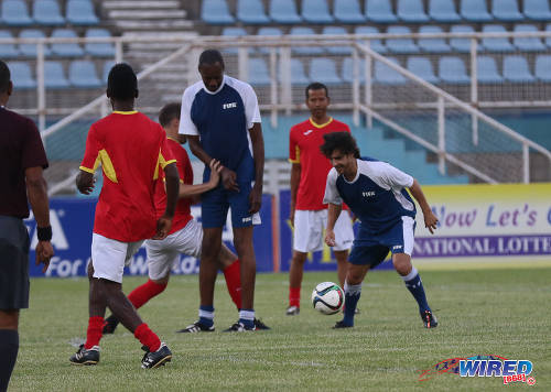 Photo: Former Argentina football star Pablo Aimar (right) runs with the ball while teammate Dennis Lawrence (centre) sets a screen during an exhibition match at the Ato Boldon Stadium in Couva on 10 April 2017. (Courtesy Sean Morrison/Wired868)