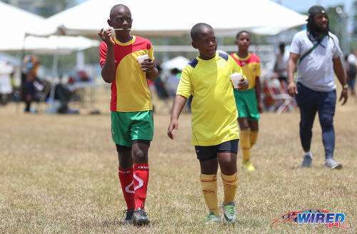 Photo: Break time! Two Trendsetter Hawks players from different under-11 teams stop for a sno cone on the opening day of RBNYL North Zone action at the Queen's Park Savannah on 22 April 2017. (Courtesy Sean Morrison/Wired868)