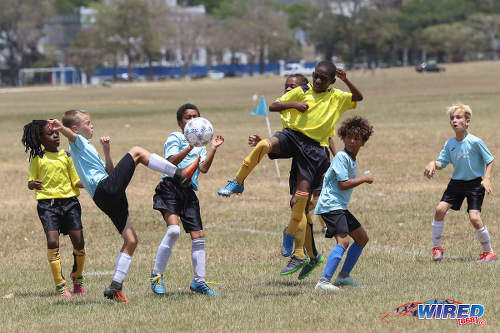 Photo: QPCC ‘1’ midfielder Logan Maingot (second from left) challenges a Trendsetter Hawks ‘2’ for the ball while his teammates Cayden Trestrail (far right) and Luke Correia (second from right) look on at the Queen's Park Savannah on 22 April 2017. QPCC won 5-1. (Courtesy Sean Morrison/Wired868)