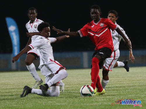 Photo: Trinidad and Tobago National Under-15 midfielder Jabari Lee (right) tries to evade a challenge from Republic Bank XI midfielder Randy Antoine during action at the Ato Boldon Stadium on 15 April 2017. (Courtesy Sean Morrison/Wired868)