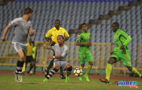 Photo: Central FC midfielder Nathaniel "Spanish" Garcia (centre) tries to caress a pass into the path of teammate Sean De Silva (far left) during 2017 Caribbean Club Championship action at the Hasely Crawford Stadium on 14 May 2017. Looking on (from right) are Grenades FC players Rakeem Henry and Nazir McBurnette and referee Sherwin Moore. (Courtesy Nicholas Bhajan/Wired868)