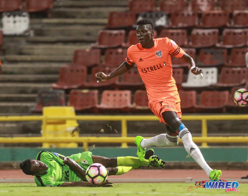 Photo: Cibao FC winger Woodensky “Babalito” Cherenfant (right) leaves Grenades FC midfielder Teran Williams for dead during Caribbean Club Championship action at the Hasely Crawford Stadium on 16 May 2017. (Courtesy Nicholas Bhajan/Wired868)