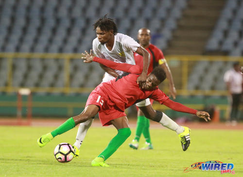 Photo: San Juan Jabloteh attacker Julio Noel (foreground) tries to hold off a challenge from a Racing Club opponent during 2017 Caribbean Club Championship action at the Hasely Crawford Stadium on 14 May 2017. Jabloteh won 2-0. (Courtesy Nicholas Bhajan/Wired868)