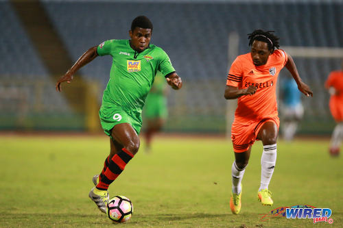 Photo: San Juan Jabloteh attacker Keithy Simpson (left) runs at Cibao FC defender Paulson Pierre during the Caribbean Club Championship final on 21 May 2017 at the Hasely Crawford Stadium in Port of Spain. Simpson and Pierre are from Jamaica and Haiti respectively. (Courtesy Allan V Crane/Wired868)