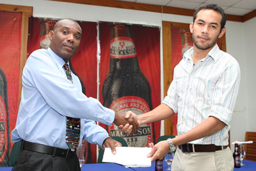 Photo: Ex-Super 10 Basketball League (SBL) managing director and commissioner Keith Clement (left) receives a cheque from Mackeson brand manager Dominic Lau. Clement is also sport editor at the Trinidad Guardian. (Copyright Trinidad Guardian)