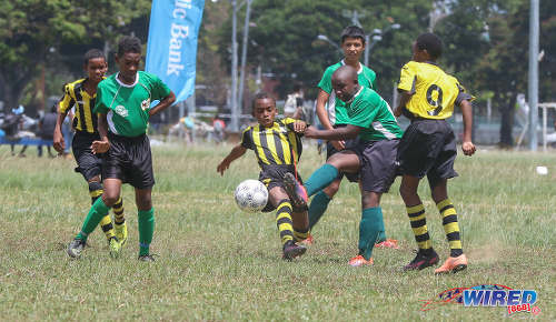 Photo: Harvard SC midfielder Ethan Paponette (left) looks on his teammate tries to force the ball past two RSSR players during RBNYL North Zone U-13 action at the Queen's Park Savannah in Port of Spain on 27 May 2017. (Courtesy Sean Morrison/Wired868)