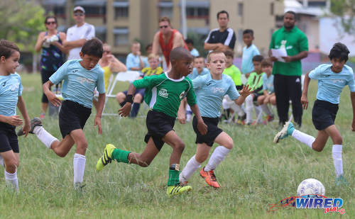 Photo: Harvard SC attacker Josh Miguel (centre) takes on four QPCC '2' players singlehandedly during RBNYL North Zone U-11 action at the Queen's Park Savannah in Port of Spain on 27 May 2017. (Courtesy Sean Morrison/Wired868)